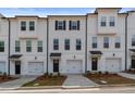 White townhomes with black-trimmed windows and attached garages at 3174 Washburn Sw St, Atlanta, GA 30354