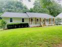 Quaint single-Gathering home showcasing a front porch with natural wood supports and a neat lawn at 641 Virginia Ave, Suwanee, GA 30024