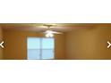 Bright living room with a ceiling fan and large window at 8101 Par Four Way, Lithonia, GA 30038