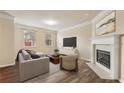Cozy living room with a fireplace, neutral-toned furniture, and hardwood floors at 2159 Meadow Peak Rd, Duluth, GA 30097