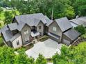 Aerial view of home with dark siding, attached three car garage, and a sprawling driveway at 564 Greystone Trce, Marietta, GA 30068