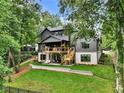 Backyard view of home showing deck, patio, and landscaped yard at 564 Greystone Trce, Marietta, GA 30068