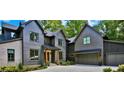 Beautiful exterior elevation of a gray modern home featuring a spacious driveway, manicured landscaping, and attached garage at 564 Greystone Trce, Marietta, GA 30068