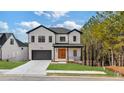 Two-story home with white brick, dark trim, and a wood front door at 9165 Golfview Ln, Covington, GA 30014