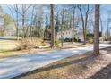 Long driveway leading to a two-story home nestled among trees at 1080 Willow Bnd, Roswell, GA 30075