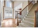 Bright foyer features hardwood floors, a staircase, and a grand entrance with French doors at 2602 Alcovy Club Dr, Dacula, GA 30019