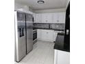 Modern kitchen with stainless steel appliances and granite countertops at 6658 Collins Ct, Riverdale, GA 30274