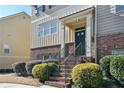 Front entry with brick steps leading to a dark-colored door and interior staircase at 3898 High Dove Sw Way # 12, Smyrna, GA 30082