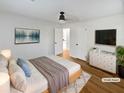 Virtually staged main bedroom with hardwood floors and neutral decor at 1048 Plainview Dr, Marietta, GA 30066