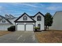 Two-story house with white siding, black accents, and a two-car garage at 2587 Alvecot Cir, Atlanta, GA 30339
