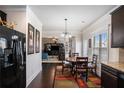 Cozy dining area with dark wood floors, a modern chandelier, and views into the adjacent living area at 520 Harmony Way, Locust Grove, GA 30248