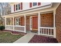 Inviting front porch with red door and white railing at 4496 Whitt Station Nw Run, Acworth, GA 30101