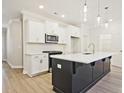 Spacious kitchen featuring white cabinets, quartz countertops, and a large island at 713 Trevett Way, Marietta, GA 30062