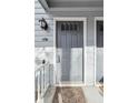 Charming front door with sidelight, complemented by a welcome mat and a stylish exterior light fixture at 3980 Riverlook Se Pkwy # 203, Marietta, GA 30067