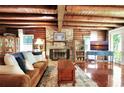 Cozy living room boasts a stone fireplace and exposed wooden beams at 305 Carrolls Way, Fayetteville, GA 30215