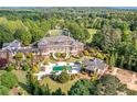 Breathtaking aerial view of the grand estate with pool and lush landscaping at 5200 Moore Rd, Suwanee, GA 30024