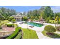 Inviting pool area with outdoor fireplace, lounge seating, and meticulous landscaping at 5200 Moore Rd, Suwanee, GA 30024