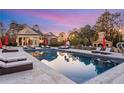 Beautiful pool featuring comfortable lounge furniture, bar and outdoor fireplace at 5200 Moore Rd, Suwanee, GA 30024