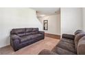 Cozy living room with plush brown sofas and neutral colored carpet at 7247 Emma Ct, Douglasville, GA 30134