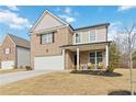 Two-story brick home with a front porch and attached garage at 5010 Ethans Cove Dr, Austell, GA 30106