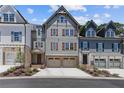 Three-story townhome with gray siding, brown accents, and a two-car garage at 228 Trecastle Sq # 24, Canton, GA 30114