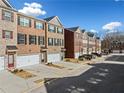 Row of townhouses with brick fronts, attached garages, and landscaping at 3075 Westpoint Cir, Snellville, GA 30078