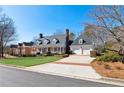 An exterior elevation of a house featuring a welcoming front porch, manicured lawn, and attached two-car garage at 1449 Brentford Cv, Snellville, GA 30078