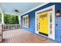 Inviting front porch with a ceiling fan and a vibrant yellow front door, creating a warm entry at 930 Custer St, Atlanta, GA 30354