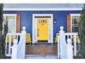 Inviting front porch with bright yellow door, rocking chairs, and blue exterior at 930 Custer St, Atlanta, GA 30354