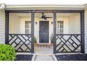 Inviting front porch featuring stylish black accents, decorative railing, and ceiling fan at 320 Windermere Dr, Loganville, GA 30052