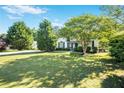 Charming home showcasing a well-manicured lawn and inviting curb appeal with mature trees at 320 Windermere Dr, Loganville, GA 30052
