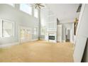 Bright living room with high ceilings, a fireplace, and large windows, offering natural light at 4267 Matisse Ln, Fairburn, GA 30213