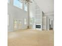 Bright living room with high ceilings, a fireplace, and large windows, offering natural light at 4267 Matisse Ln, Fairburn, GA 30213