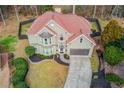 Aerial shot of a landscaped yard with retaining wall, black mulch, a traditional elevation and a large driveway at 1692 Branch Creek Cv, Lawrenceville, GA 30043