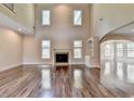 Two-story living room with hardwood floors and a fireplace at 7890 Royal Melbourne Way, Duluth, GA 30097