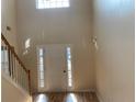 Bright entryway with hardwood floors, a soaring ceiling, and a staircase, creating a welcoming atmosphere at 7981 Gossamer Dr, Fairburn, GA 30213