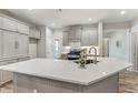 Modern kitchen with white quartz island, gray cabinets, and stainless steel appliances at 1540 Cloverleaf Pl, Cumming, GA 30041