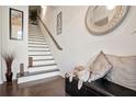 Modern white staircase with dark hardwood floors at 7711 Cabrini Pl, Fairburn, GA 30213