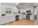 Modern white kitchen with stainless steel appliances and quartz countertops at 4519 Glenforest Ne Dr, Roswell, GA 30075