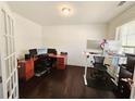 Home office with wood floors, two desks and multiple monitors at 1690 Geranium Ln, Cumming, GA 30040