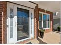 Front entry with brick facade, storm door and window at 3648 Ramsey Close Sw, Atlanta, GA 30331