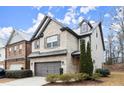 Two-story home with attached garage, landscaping and snowy scene at 8775 Village Pl, Suwanee, GA 30024