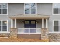 Inviting front porch with blue double doors and stone pillars at 9385 N Lake Dr, Roswell, GA 30076