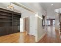 Hallway with hardwood floors, built-in bookshelves, and access to multiple rooms and staircase at 340 Town Center Ave # 215, Suwanee, GA 30024
