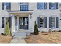 Charming home featuring a gray brick facade, black shutters, a covered porch and an inviting entrance at 5702 Brynwood Nw Cir, Acworth, GA 30101
