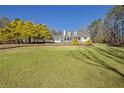White house with stone accents, a wrap-around porch, and a large yard at 4320 Chapel Hill Farms Dr, Douglasville, GA 30135
