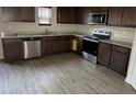 Modern kitchen featuring dark wood cabinets and stainless steel appliances at 132 Oliver Dr, Locust Grove, GA 30248