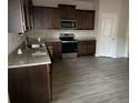 Modern kitchen with dark wood cabinets, granite counters, and stainless steel appliances at 132 Oliver Dr, Locust Grove, GA 30248
