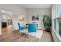 Cozy dining space with a wooden table and two teal chairs near a large window at 1259 Mill Lake Cir, Stone Mountain, GA 30088