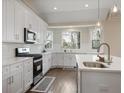 Modern kitchen features white cabinetry, stainless steel appliances, and views of the outdoors at 366 Greycoat Sw Blf, Marietta, GA 30064